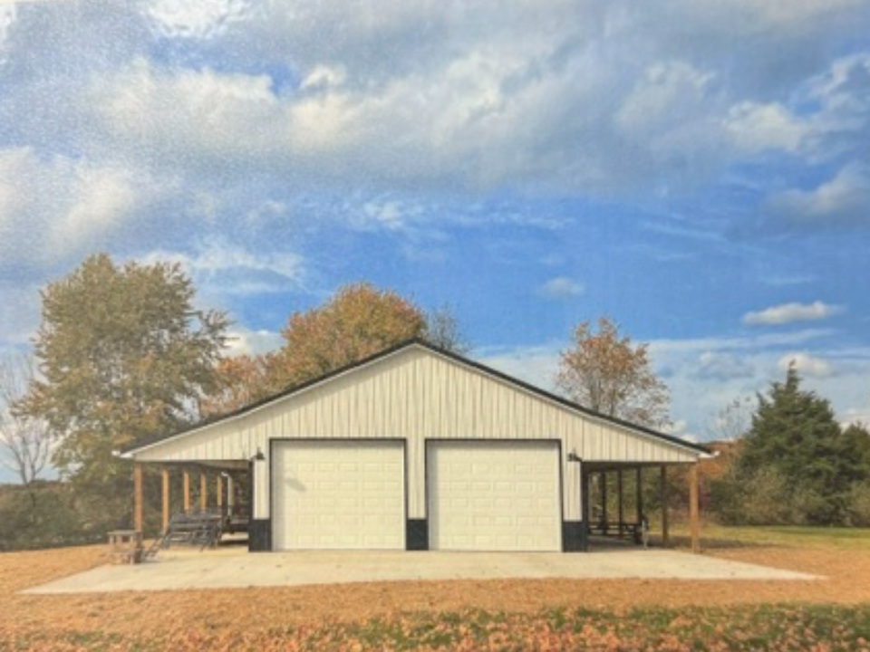 Modern two-bay garage with tan metal siding and covered side porches in rural setting