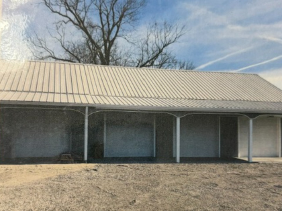 Large metal barn with covered carport sections and metal roof